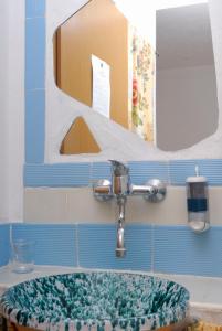 un lavandino con rubinetto e specchio di Villa Saracina a Vulcano