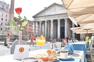 un tavolo con cibo e un bicchiere di succo d'arancia di Di Rienzo Pantheon Palace a Roma
