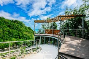 a wooden bridge with a bench on a walkway at Zeleny Guy Health Resort in Tuapse