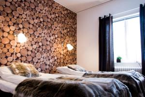 2 camas en una habitación con troncos en la pared en Marsfjäll Mountain Lodge Hotell, en Saxnäs