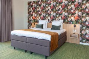 1 dormitorio con 1 cama grande y pared de flores en Best Western Plus Hotel Amstelveen en Amstelveen