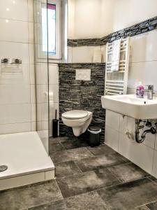 a bathroom with a toilet and a sink at AVI City Apartments MainHouse in Düsseldorf