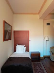 Schlafzimmer mit einem großen Bett mit einem Kopfteil aus Holz in der Unterkunft Hotel Rural Quinta Do Pego in Tabuaço