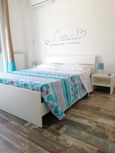 a bedroom with a white bed with a blue blanket at B&B Sapore di Mare san salvo Marina in San Salvo
