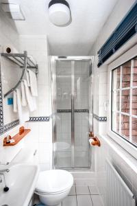 a bathroom with a shower and a toilet and a sink at Trivelles Waterhall Country Gatwick Hotel & airport parking in Crawley +117 photos
