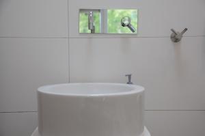 W białej łazience znajduje się umywalka i lustro. w obiekcie Bed Breakfast Boat w Amsterdamie