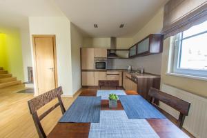 cocina con mesa con 2 sillas y ventana en Apartments Ameda en Vilna
