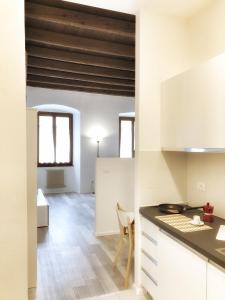 a kitchen with white cabinets and a counter top at Al Belenzani Appartamento in Trento