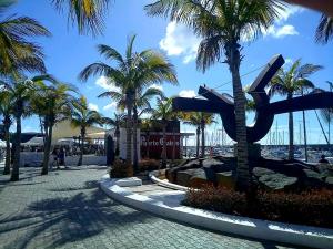 una strada con palme e la statua di un aereo di Velero Babu a Puerto Calero