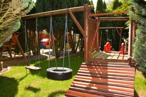a playground with a swing and a tire at U Gosa in Ustronie Morskie