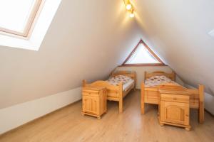 a attic room with two beds and a window at Domek Osada Gubałówka Zakopane in Słodyczki