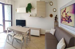 een woonkamer met een tafel en een bank bij La Quiete 27 Lake view by Gardadomusmea in Tremosine Sul Garda