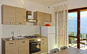 een keuken met een koelkast en een tafel met stoelen bij La Quiete 27 Lake view by Gardadomusmea in Tremosine Sul Garda