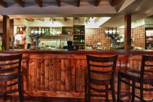 a bar with four wooden chairs and a table at The Village Inn in Northallerton