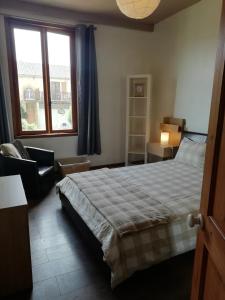 1 dormitorio con 1 cama, 1 silla y 1 ventana en Maison de Maitre II en Availles-Limouzine