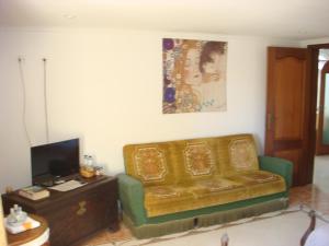 a living room with a couch and a tv at Casa De Hospedes Flor Do Jardim in Malveira