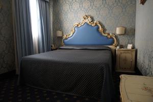 a bed with a white bedspread and pillows at Hotel Rialto in Venice
