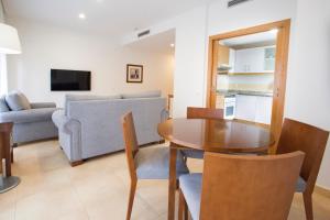 a living room with a table and a couch at Aparthotel Albufera in Alfafar
