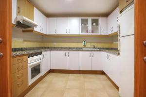 an empty kitchen with white cabinets and appliances at Aparthotel Albufera in Alfafar