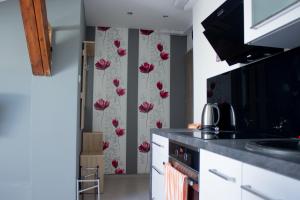 una cocina con flores rojas en la pared en Apartament Stawowa, en Cieszyn