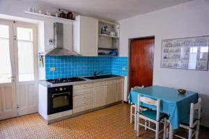 a kitchen with a stove and a table in it at Bilocale Pascoli in Santa Teresa Gallura