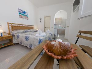 a bedroom with two beds and a table with a shell on it at Il corallo rosso in Favignana