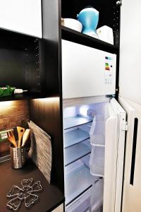un frigorifero con porta aperta e stoviglie di MACAIA a Lavagna