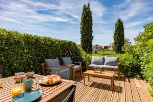a patio with a table and chairs on a wooden deck at Green Suite Golfe de Saint Tropez in Gassin