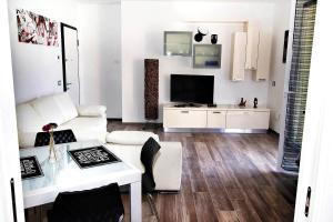 a living room with a white couch and a tv at MACAIA in Lavagna