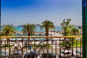a view of a beach with palm trees and cars at Apartments & Rooms Grašo in Split