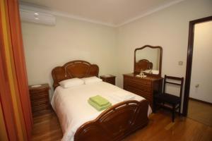 een slaapkamer met een bed met een spiegel en een stoel bij Casa Bela Vista in Geres