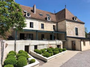 Ein Gebäude mit Büschen davor. in der Unterkunft Logis L'Hôtel D'Arc in Arc-sur-Tille