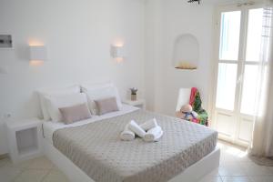 a white bedroom with a bed with two towels on it at Maistrali in Provatas