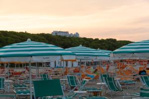 - un groupe de chaises longues et de parasols sur une plage dans l'établissement Camping & Village Eucaliptus, à Alba Adriatica