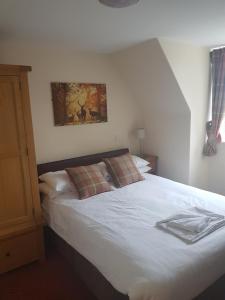 a bedroom with a white bed and white walls at The Station Hotel in Alness