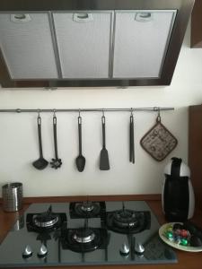 a row of utensils hanging on a wall above a stove at Staurenghi34apartmenT in Varese