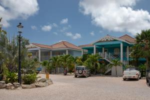 duży dom z samochodami zaparkowanymi przed nim w obiekcie Ocean Blue Bonaire w mieście Kralendijk
