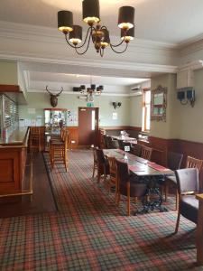 a restaurant with tables and chairs and a dining room at The Station Hotel in Alness