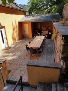 um pátio exterior com uma mesa de madeira e cadeiras em Ferienhaus an der Sesselbahn em Cochem