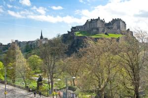 a castle on top of a hill with trees at Destiny Scotland Charlotte Square Apartments in Edinburgh