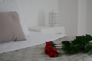 a bed with a bouquet of red roses on it at Maistrali in Provatas