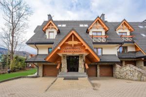 a large house with a gambrel roof on top at Apartamenty Montana in Zakopane