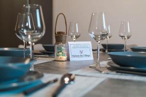 a table with wine glasses and a sign on it at Maison du Village - Sesimbra in Sesimbra