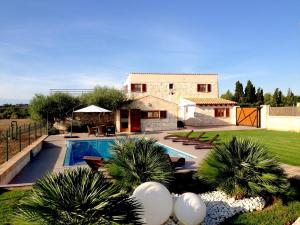 a house with a swimming pool in the yard at Vinagrella in Llubí