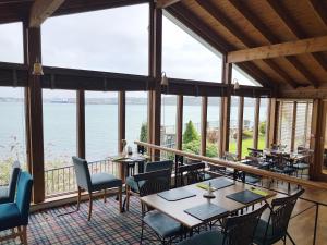a restaurant with tables and chairs and a view of the water at Ferry House Inn in Milford Haven
