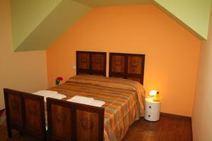 a bedroom with a bed with an orange wall at Il Principe B&B in Alì Terme