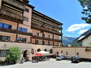 ein großes Gebäude mit Autos auf einem Parkplatz in der Unterkunft Hotel Bündnerhof in Davos