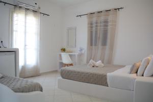 a white bedroom with a bed with a bow on it at Maistrali in Provatas