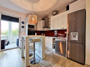 cocina con electrodomésticos de acero inoxidable y mesa con taburete en Veduta Luxury Apartments, en Split