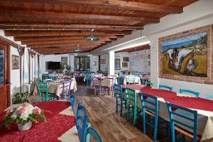 a restaurant with tables and chairs and a painting on the wall at Agriturismo Codula Fuili in Cala Gonone